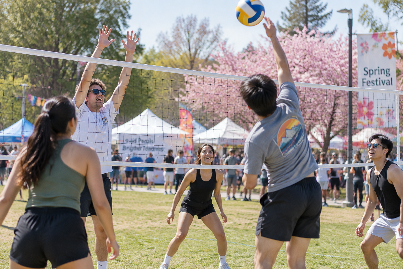 Jóvenes jugando al voleibol en una cancha al aire libre durante una fiesta de primavera.