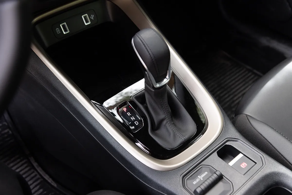 Primer plano de la palanca de cambios automática y los comandos de la consola central de un Jeep Avenger.