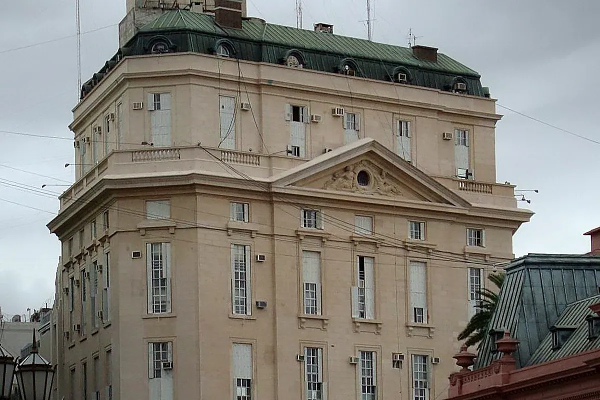 Edificio de estilo clásico con fachada beige, frontón esculpido y techo de pizarra verde con buhardillas, sede de la Secretaría de Inteligencia de Estado en la calle 25 de Mayo, Buenos Aires.
